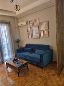比雷埃夫斯Piraeus open view Appartment的客厅配有蓝色的沙发和茶几
