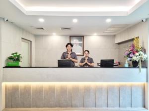 曼谷康帕斯酒店集团曼谷思庭水门酒店的两个妇女在等候室的柜台上坐
