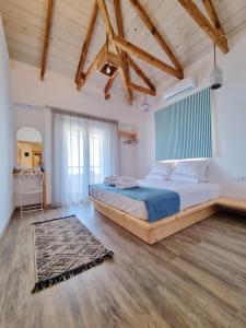 利迈纳里亚Votsalo Cozy Apartments的一间带一张大床的卧室,位于一个拥有木制天花板的房间