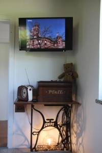费尔德基兴Ferienhaus Kärntnergmiat的墙上的电视,桌子上挂着泰迪熊