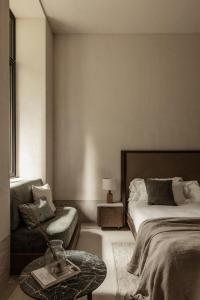 瓦尔特西尼科MANNA的一间卧室配有一张床、一把椅子和一张桌子