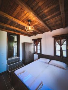 培拉特Bujtina Bega的一间卧室设有一张带木制天花板的大床