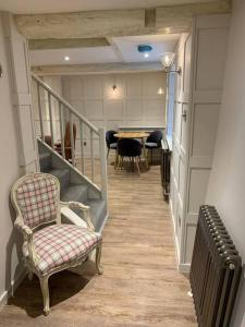 威尔汉姆Cosy Modern Cottage - Wareham的走廊设有楼梯、椅子和桌子