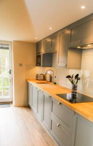 威尔汉姆Cosy Modern Cottage - Wareham的厨房配有不锈钢橱柜和水槽