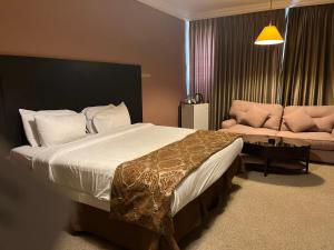 安曼牧羊人酒店的一间卧室配有一张大床和一张沙发