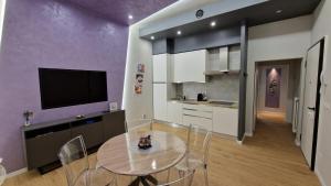 博洛尼亚CASA FORTUNATO的厨房以及带桌子和电视的用餐室。