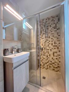 雷夫卡达镇Memoria Apartments by Imagine Lefkada的一间带水槽和淋浴的浴室