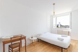索恩河畔自由城Cabana & Grand appartement cosy - Parking & Balcon的一间卧室配有一张床、一张书桌和一个窗户。