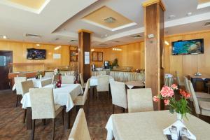 阳光海滩Briz - Seabreeze Hotel的一间设有白色桌椅的餐厅和一间酒吧