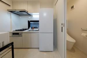 东京Setagaya House的厨房配有白色冰箱和水槽