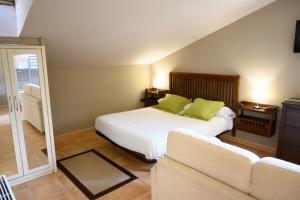 伊巴兰格鲁Hotel Spa Gametxo的一间卧室配有一张带绿色枕头的床和一张沙发