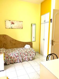 莱切OSTELLO MADRE SANTINA的一间卧室设有床和黄色的墙壁
