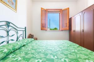 Marina di LeucaSalentoandmore - Anna Rita Guest House的一间卧室设有一张带窗户的绿色床