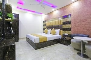 新德里Hotel Grand LA CASA Near IGI airport的酒店客房配有一张床铺和一张桌子。