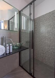 阿波罗尼亚Armenakishouses的一间带玻璃淋浴间和水槽的浴室