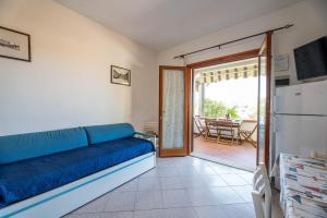费拉约港Casa Luppoli的客厅设有蓝色的沙发和滑动玻璃门