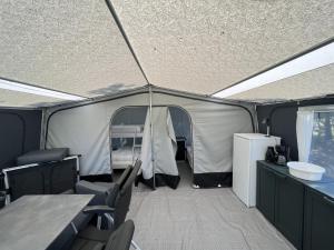 BredebroBredebro camping的一个带椅子和桌子的帐篷以及一台冰箱