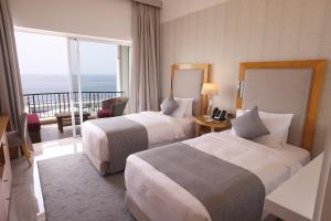 贝鲁特Riviera Hotel and Beach Lounge, Beirut的酒店客房设有两张床和一个阳台。