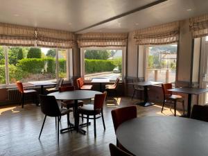 佩罗斯-吉雷克Hotel Restaurant Le Phare的餐厅设有桌椅和窗户。