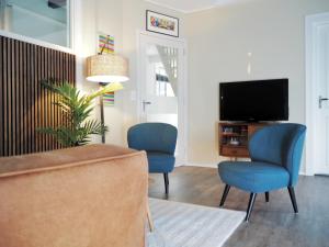 Wirdum‘t Wirdummer Hof - family-friendly guesthouse的客厅配有2把蓝色椅子和电视