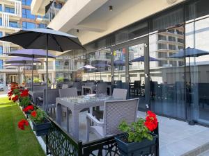 北马马亚-讷沃达里Hotel Javu的一个带桌椅和遮阳伞的户外庭院。
