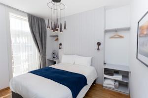 坎特伯雷Number 8的一间卧室配有一张白色的床和蓝色的毯子