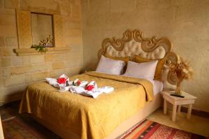阿瓦诺斯Mozaik Stone Hotel的一间卧室配有带毛巾和鲜花的床