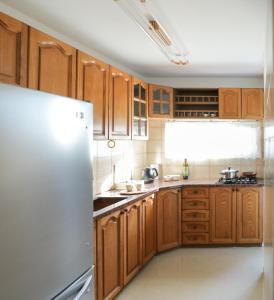 巴特亚姆Краткосрочная посуточная аренда Бат-Ям!的厨房配有木制橱柜和白色冰箱。