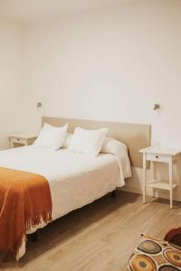 圣克鲁斯-德特内里费Apartamento de la Candelaria I的卧室配有白色的床和桌子