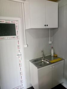 穆拉Karavan Kır Evi的一个带水槽和白色橱柜的小厨房
