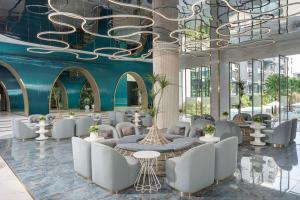 华欣Best Western Plus Carapace Hotel Hua Hin的大堂设有白色的桌椅和蓝色的墙壁