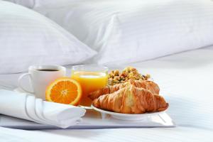 乔普林乔普林旅居酒店的包括羊角面包和橙子的早餐盘和一杯咖啡