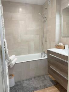 梅塔比耶Appartement cosy的白色的浴室设有浴缸和水槽。