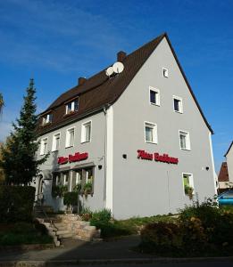 黑措根奥拉赫Altes Backhaus的一座白色的大建筑,上面有红色的标志