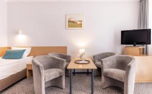 索利纳苏霖纳度假酒店&Spa中心的酒店客房带一张床、一张桌子和椅子