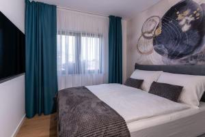 乌马格Capsula Luxury Apartment Umag的一间卧室配有一张带蓝色窗帘的大床