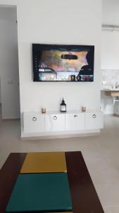 比塞大EVA'S HOME的客厅设有壁挂式平面电视。