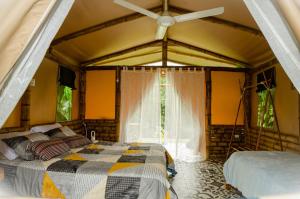 瓜杜阿斯Aguas Claras Bamboo Ecolodge的一间卧室配有一张床和吊扇