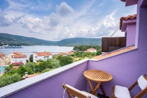 茨雷斯拉凡达别墅酒店的阳台拥有紫色的墙壁,配有桌椅。