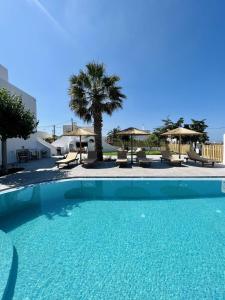 梅萨雷亚Santorini Villatzio Suites的一个带椅子和遮阳伞的大型蓝色游泳池