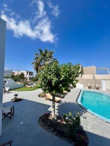 梅萨雷亚Santorini Villatzio Suites的院子里有树的游泳池