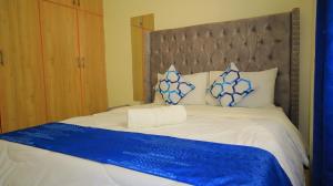 Langata RongaiSpringStone apartment 1 bedroom no 5的一张配有蓝色和白色床单及枕头的大床