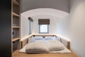 帕尔奇内斯Alpin & Stylehotel Die Sonne的卧室配有白色的床和窗户