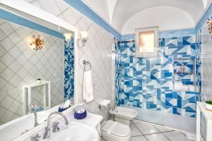 卡普里Le Botteghe 59 Capri的蓝色和白色的浴室设有浴缸和卫生间