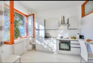 拉韦诺Apartment With View Lake Maggiore/Laveno Mombello的白色的厨房配有炉灶和窗户。