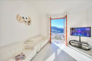 拉韦诺Apartment With View Lake Maggiore/Laveno Mombello的客厅配有白色沙发和平面电视。