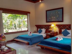 甘地达萨卡迪达萨普里巴古斯酒店的一间卧室设有两张床和大窗户
