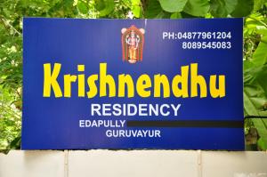 古鲁瓦尤尔Fresh Up In Guruvayur Krishnendhu Residency的墙上的蓝色标志,上面写着一个读书的书