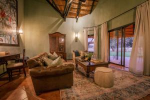 温特和克Okapuka Safari Lodge的客厅配有沙发和桌子