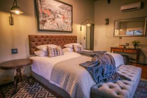温特和克Okapuka Safari Lodge的一间卧室配有一张床、一张桌子和一面镜子